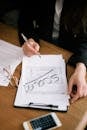 pexels-photo-7247400-7247400 A person marking documents as scam with glasses and a calculator nearby.